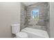Clean bathroom with grey tile and a shower/tub combo at 450 Albatross Rd, Rotonda West, FL 33947