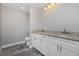 Modern bathroom with granite countertop, white cabinets, and gray tile floor at 450 Albatross Rd, Rotonda West, FL 33947