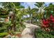 Brick pathway winds through lush tropical landscaping, creating a serene walkway at 10311 Lands End Cir # 13, Placida, FL 33946
