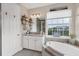 Elegant bathroom with soaking tub, double vanity, and large window at 10311 Lands End Cir # 13, Placida, FL 33946