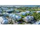 Aerial view of a waterfront community with a large lake, pool, and tennis courts at 10311 Lands End Cir # 13, Placida, FL 33946