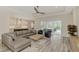 Open concept living room with a grey sectional sofa, wood coffee table, and view of the pool at 12424 Davie Ct, Venice, FL 34293