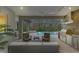 Outdoor kitchen, pool, and seating area with screened enclosure at 12424 Davie Ct, Venice, FL 34293