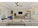 Living area with sectional sofa, large TV, and view into a bedroom at 12424 Davie Ct, Venice, FL 34293