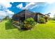 Screened patio with lush landscaping at 15658 Stuart Cir, Port Charlotte, FL 33981