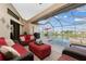 Relaxing enclosed patio with pool view, wicker furniture, and red accents at 15658 Stuart Cir, Port Charlotte, FL 33981