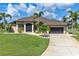 One-story home with a tile roof, screened garage, and landscaped yard at 15658 Stuart Cir, Port Charlotte, FL 33981
