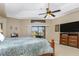 Primary bedroom with a king-size bed, large TV, and sliding glass doors to the lanai at 15658 Stuart Cir, Port Charlotte, FL 33981