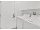 Bright laundry room with washer, dryer, and ample cabinet storage at 308 Capatola St, Port Charlotte, FL 33948