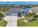 Single-Gathering home with a gray exterior, two-car garage, and a well-maintained lawn at 10083 Kansas City St, Port Charlotte, FL 33981