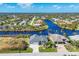 Aerial view of a waterfront property, showing a canal and surrounding houses at 10083 Kansas City St, Port Charlotte, FL 33981