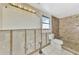 Partially renovated bathroom with new toilet, tiled shower, and exposed wall framing at 105 Crestview Dr, Englewood, FL 34223