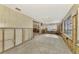 A Florida room with jalousie windows, wood paneling, and unfinished concrete floor at 105 Crestview Dr, Englewood, FL 34223