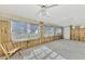 Spacious, sunlit Florida room featuring numerous jalousie windows, a door, and some wooden paneling at 105 Crestview Dr, Englewood, FL 34223