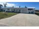Front exterior showcasing the home's facade, driveway, and lush lawn at 105 Crestview Dr, Englewood, FL 34223