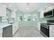 Modern kitchen with white cabinets, stainless steel appliances, and tile floors at 217 Rotonda Cir, Rotonda West, FL 33947