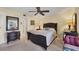 Main bedroom with a queen-size bed, ceiling fan, and access to en-suite bathroom at 23 Quails Run Blvd # 2, Englewood, FL 34223