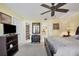 Main bedroom with a king-size bed, ceiling fan, and en-suite bathroom at 23 Quails Run Blvd # 2, Englewood, FL 34223