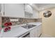 Bright kitchen features ample cabinetry, stainless steel sink, and modern appliances at 23 Quails Run Blvd # 2, Englewood, FL 34223