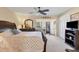 Spacious main bedroom with a king-size bed, ceiling fan, and en-suite bathroom access at 23 Quails Run Blvd # 2, Englewood, FL 34223