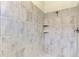 Clean shower with grey tile and built-in shelving at 25122 Spartina Dr, Venice, FL 34293