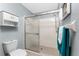 Tiled bathroom featuring a glass shower enclosure, toilet, and storage cabinet at 404 Pine Hollow Cir # 404, Englewood, FL 34223