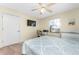 Well-lit bedroom with ceiling fan and window, featuring a cozy bed and compact desk area at 404 Pine Hollow Cir # 404, Englewood, FL 34223
