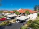 A view of condos with carport parking, landscaping, and red tile roof at 404 Pine Hollow Cir # 404, Englewood, FL 34223