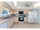 Functional kitchen with wood cabinets, black appliances, and ample counter space for meal preparation at 404 Pine Hollow Cir # 404, Englewood, FL 34223