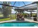 Outdoor oasis with pool, grill, patio furniture, and golf course view at 4663 Arlington Dr, Placida, FL 33946