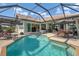 Inviting pool area with screened enclosure, patio furniture, and lush landscaping at 4663 Arlington Dr, Placida, FL 33946