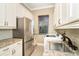 Laundry room with stainless steel appliances and granite counters at 65 Par View Ter, Rotonda West, FL 33947