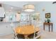 Cozy dining area with white chairs, a round wood table, and pendant lighting at 6800 Placida Rd # 207, Englewood, FL 34224