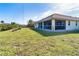 House exterior view from the side showcasing a large backyard and screened patio at 156 Crevalle Rd, Rotonda West, FL 33947