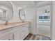 Double vanity bathroom with large mirrors and view of bedroom and water at 2424 Placida Rd # C202, Englewood, FL 34224