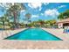 Community pool with lounge chairs and surrounding patio at 404 Pine Hollow Cir # 404, Englewood, FL 34223