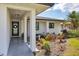 Inviting front entrance with covered porch, landscaping, and modern door at 931 Caples St, Englewood, FL 34223