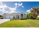Exterior view of a single-story house with a three-car garage and palm trees at 110 Abercrombie Ave, Englewood, FL 34223