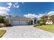 Single-story home with a two-car garage and landscaped yard at 110 Abercrombie Ave, Englewood, FL 34223