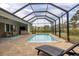 Relaxing pool area with lounge chair and screened enclosure at 12194 Everglades Ave, Port Charlotte, FL 33981