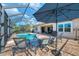 Screened pool with patio furniture and umbrella, ideal for relaxation at 13324 Golf Pointe Dr, Port Charlotte, FL 33953