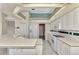 Kitchen features white appliances and an island at 13783 Palmetto Point Ct, Port Charlotte, FL 33953