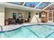 Refreshing pool with a screened enclosure and patio furniture at 152 Apollo Dr, Rotonda West, FL 33947