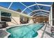 Screened pool and spa with patio furniture and a tiki bar at 152 Apollo Dr, Rotonda West, FL 33947