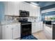 Modern kitchen with black appliances and white cabinets at 15674 Applewhite Cir, Port Charlotte, FL 33981