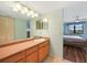 Bright bathroom with wood cabinets and a view of the bedroom at 175 Kings Hwy # 236, Punta Gorda, FL 33983