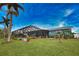 Landscaped backyard with a screened pool cage and lush tropical plants at 189 Carlisle Nw Ave, Port Charlotte, FL 33952