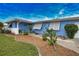 Front walkway to light blue home with white shutters and well maintained landscaping at 189 Carlisle Nw Ave, Port Charlotte, FL 33952