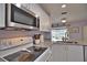 White kitchen cabinets, granite countertops, and stainless steel appliances at 189 Carlisle Nw Ave, Port Charlotte, FL 33952