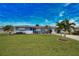 Single-story home with blue exterior, white accents, landscaping, and palm trees at 189 Carlisle Nw Ave, Port Charlotte, FL 33952